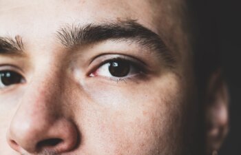 A young man stares at the camera. Brown man's eyes close up. Male face close up.