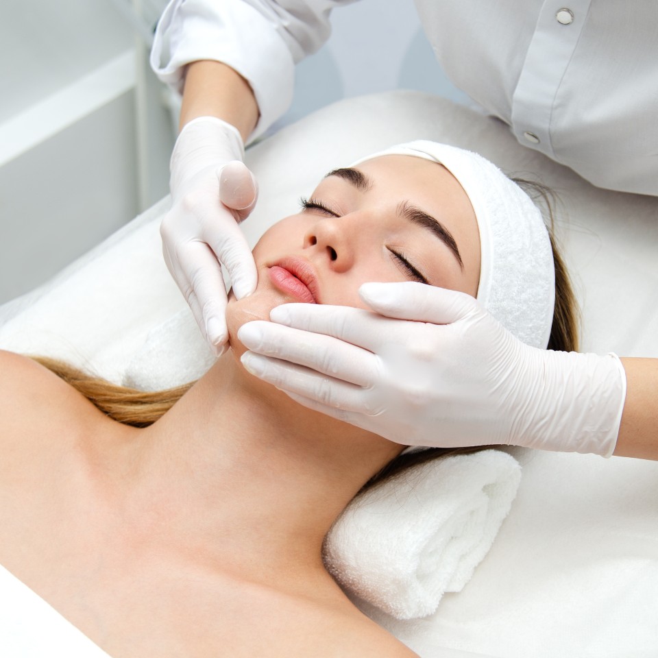 Woman getting face beauty treatment in medical spa center.
